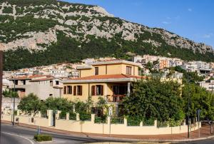 a yellow house in front of a mountain at Guest House DaLù in Dorgali