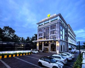 a building with cars parked in a parking lot at The Monarch Hotel & Convention Centre in Trivandrum