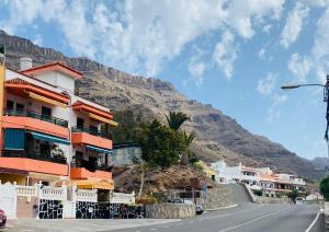a street in a town with a mountain in the background at Apartmán - MARIS in Puerto de Mogán