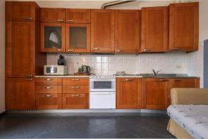 een keuken met houten kasten en een witte kookplaat bij Appartamento lungo il Sentiero del Viandante Lecco in Lecco