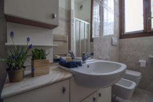 La salle de bains est pourvue d'un lavabo et de toilettes. dans l'établissement Appartamento lungo il Sentiero del Viandante Lecco, à Lecco