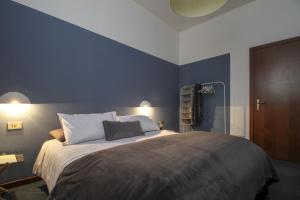 een slaapkamer met een groot bed met blauwe muren bij Appartamento lungo il Sentiero del Viandante Lecco in Lecco