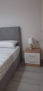 a bedroom with a bed and a nightstand with a lamp at Nikiana Family Apartment in Nikiana
