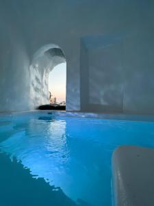 una piscina de agua azul en un edificio en Oinos Luxury Suites Caldera, en Oia