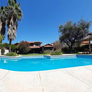 a large blue swimming pool in front of a house at Casona en Barrio Privado Lujan de Cuyo in Ciudad Lujan de Cuyo