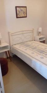 a bedroom with a bed with two tables and a picture on the wall at Traditional SeamansHouse Kochilos in Rogón