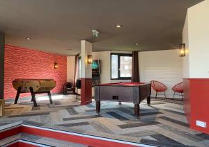 een kamer met 2 pooltafels en een bakstenen muur bij Résidence Odalys Tourotel in Val Thorens