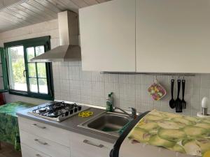 a kitchen with a sink and a stove at Casetta Arùci Marzamemi Holidays in Marzamemi