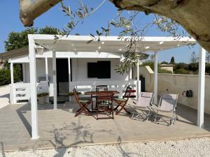 a pavilion with a table and chairs on a patio at Casetta Arùci Marzamemi Holidays in Marzamemi