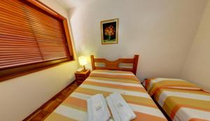 two beds in a small room with a window at Pousada Albuquerque in Teresópolis +14 photos