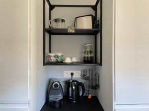 a kitchen with a coffee maker on a shelf at Tiny House in Limburg bij Kelly & Nick in Ham