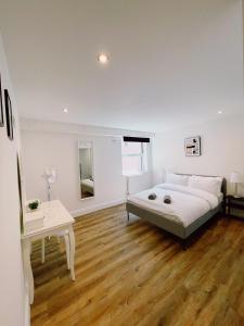 a white bedroom with a bed and a table at Prosper House Apartment 4 in Norwich