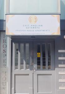 a building with a sign over the doors of a building at Prosper House Apartment 4 in Norwich