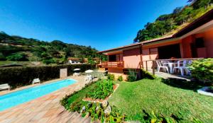 a backyard with a swimming pool and a house at Pousada Albuquerque in Teresópolis