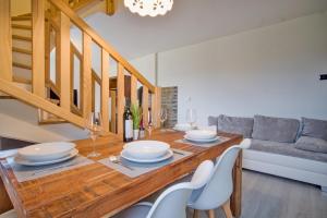 a dining room with a table with chairs and a couch at Rezidence Podkova in Frymburk +6 photos