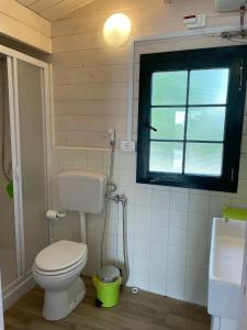 a small bathroom with a toilet and a window at Casetta Arùci Marzamemi Holidays in Marzamemi