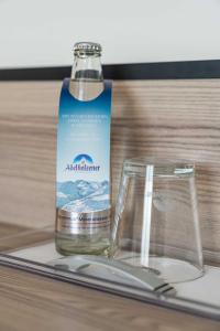 een fles water en een glas op een tafel bij Abasto Hotel Dachau in Dachau