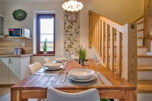 a dining room with a wooden table and white chairs at Rezidence Podkova in Frymburk