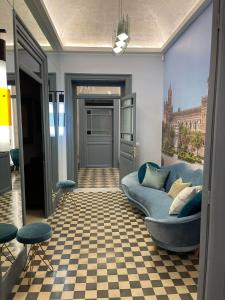 a living room with a blue couch and a checkered floor at I Bastioni Apartment in Palermo