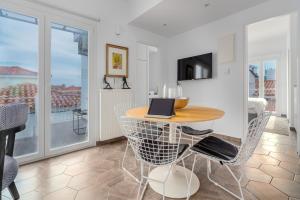 a room with a table and chairs with a laptop on it at Mare Gaia Apartments in Skiathos