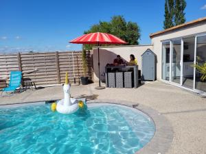 einen Pool mit einem Schwan in der Mitte in der Unterkunft La pool house in Saint-Aubin-du-Plain
