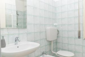 een witte badkamer met een wastafel en een toilet bij Appartamento Ginepro in Cala Liberotto