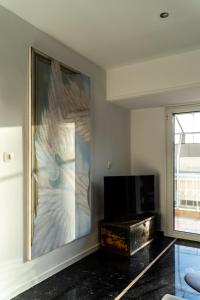 a living room with a large painting on the wall at Luxury penthouse , breathtaking Acropolis view in Athens