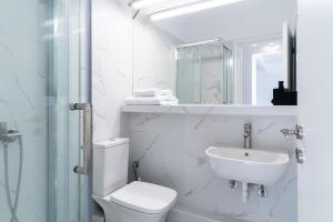 a white bathroom with a toilet and a sink at Luxury penthouse , breathtaking Acropolis view in Athens