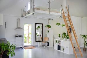a room with a loft bed with plants and a ladder at Studio Solbakke Hvaler - Modern studio close to sea in Rød