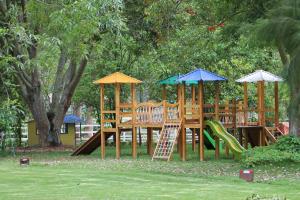 a park with a playground with a slide and umbrellas at Posada del Puruay in Cajamarca