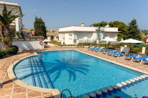 a large swimming pool with chairs and a building at Bravissimo Vil·les Brusi B S'Agaró in S'Agaro