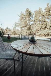 a wooden table and chairs on a wooden deck at House 100 m to the sea in Monciske, free parking in Monciškės