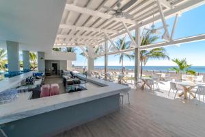 un vestíbulo con una playa con mesas y sillas en Oceana Resort & Conventions, en Monterrico