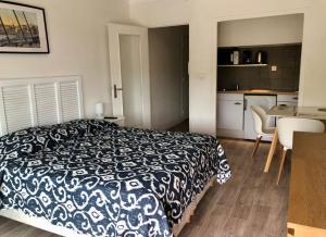 Cet appartement comprend une chambre avec un lit noir et blanc et une cuisine. dans l'établissement Résidence meublée STUDIOTEL, à Cagnes-sur-Mer