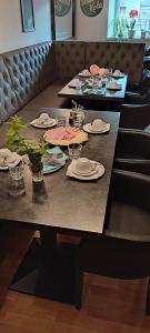 einen langen Tisch mit Tellern und Gläsern darauf in der Unterkunft Gästezimmer & Apartment Mayrhofer in Waidhofen an der Ybbs