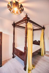 a bedroom with a canopy bed and a chandelier at Bildstein's "Dharamsala" in Langenfeld