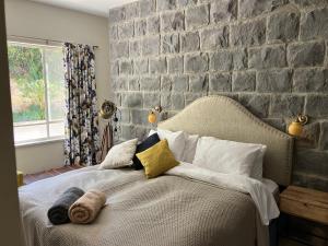 a bed in a bedroom with a stone wall at Villa Dadia - Rosh Pina in Rosh Pinna