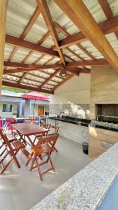 a kitchen with a table and chairs and an umbrella at Residencial Rocha - Praia de Guaratiba - Prado - Ba in Prado