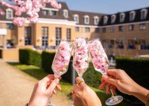 a group of people holding up wine glasses with flowers at Heerlickheijd van Ermelo in Ermelo