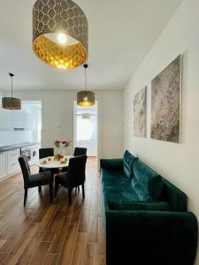 - un salon avec un canapé vert et une table dans l'établissement Lux Apartmans, à Pula