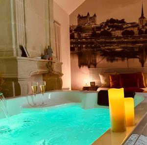 a jacuzzi tub in a room with a bed at Entre Nous Le Joachim in Saumur