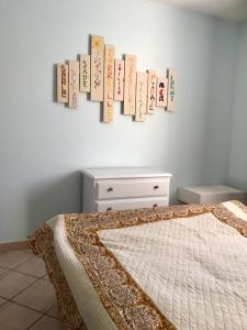 a bedroom with a bed with books hanging on the wall at Gîte de Leni - Maison avec piscine in Torreilles