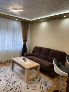 a living room with a couch and a coffee table at Апартамент ВАНЕСА in Velingrad