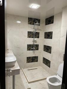 y baño con ducha, aseo y lavamanos. en Апартамент ВАНЕСА en Velingrado