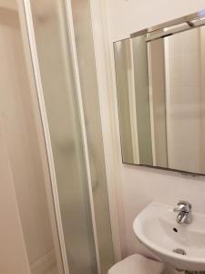 La salle de bains blanche est pourvue d'un lavabo et d'un miroir. dans l'établissement Al Portico Guest House, à Venise