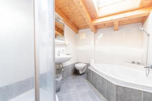 łazienka z wanną, toaletą i umywalką w obiekcie Appartements Olympia w Mayrhofen