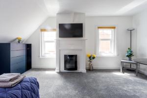 a white room with a fireplace with a tv on top at Beach View Luxury Apartment in Lyme Regis