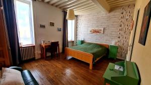 a bedroom with a green bed in a room at Ambiance Morvan in Ouroux