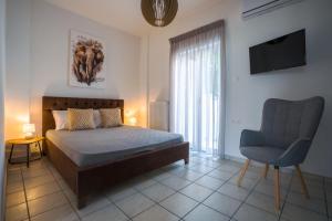 a bedroom with a bed and a chair and a television at Eden’s garden in Chania Town