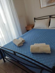 een slaapkamer met een bed met handdoeken erop bij Syros House with View in Ermoupoli